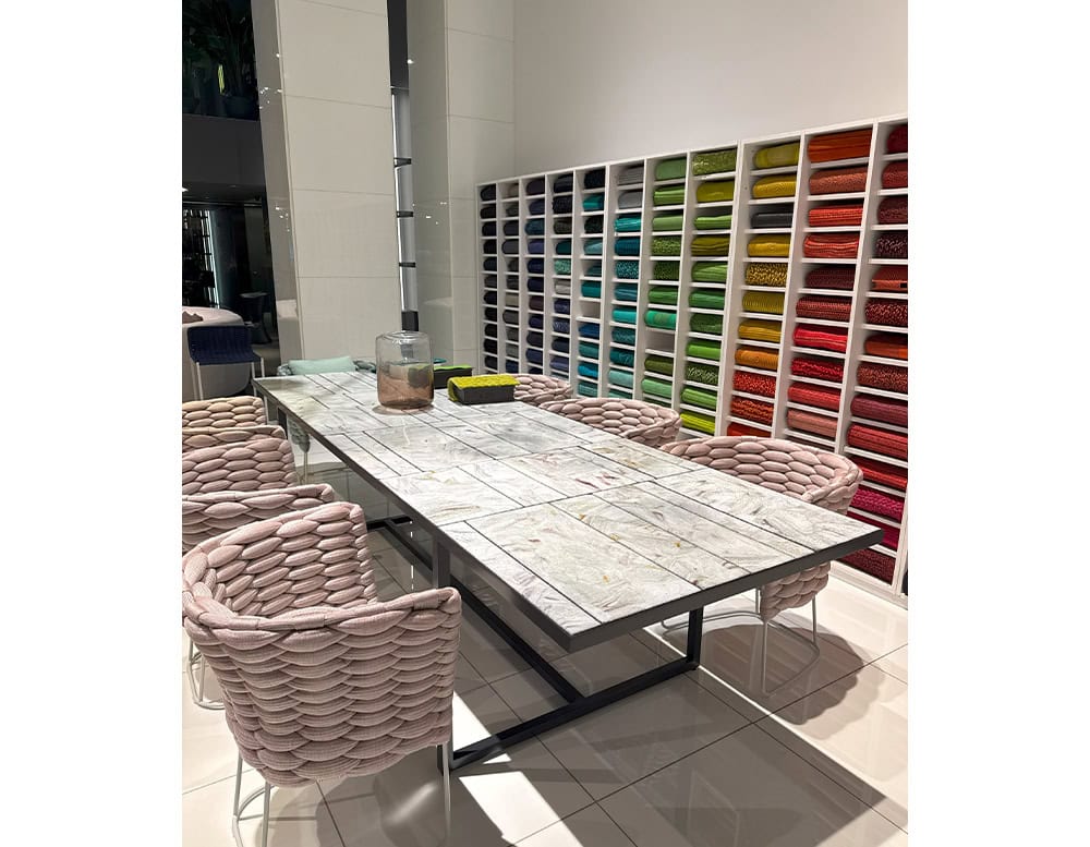PL Sciara Outdoor Dining Table Gray anchors the space with its glazed tile top and black steel frame. Surrounded by sculptural pink rope chairs, it makes a bold statement in both color and texture.