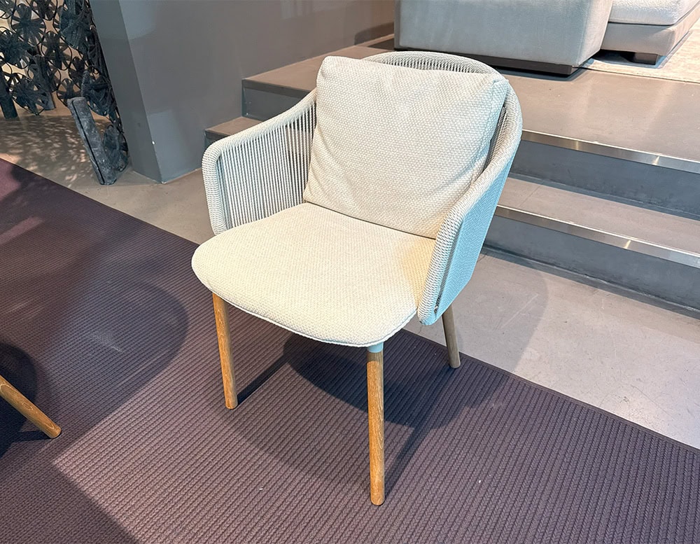 The Tri Senja Outdoor Dining Chair combines soft woven rope with plush cushioning and warm teak legs. Its inviting curves and refined textures offer both comfort and elegance for contemporary outdoor dining.