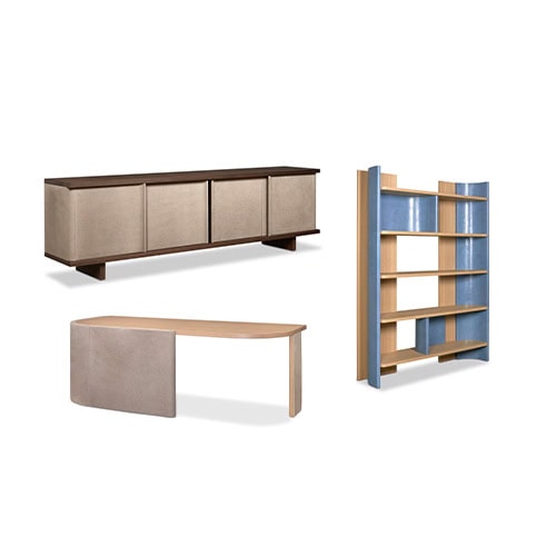 A sideboard with clean lines stands alongside an open shelving unit featuring blue lacquered accents. In front, a curved desk combines a light wood top with a soft-tone structural base.