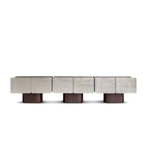 The GR Admira Cabinet features a brushed silver-toned finish on its modular front panels, resting on cylindrical bases in a rich brown tone. The design combines geometric minimalism with bold, sculptural proportions.