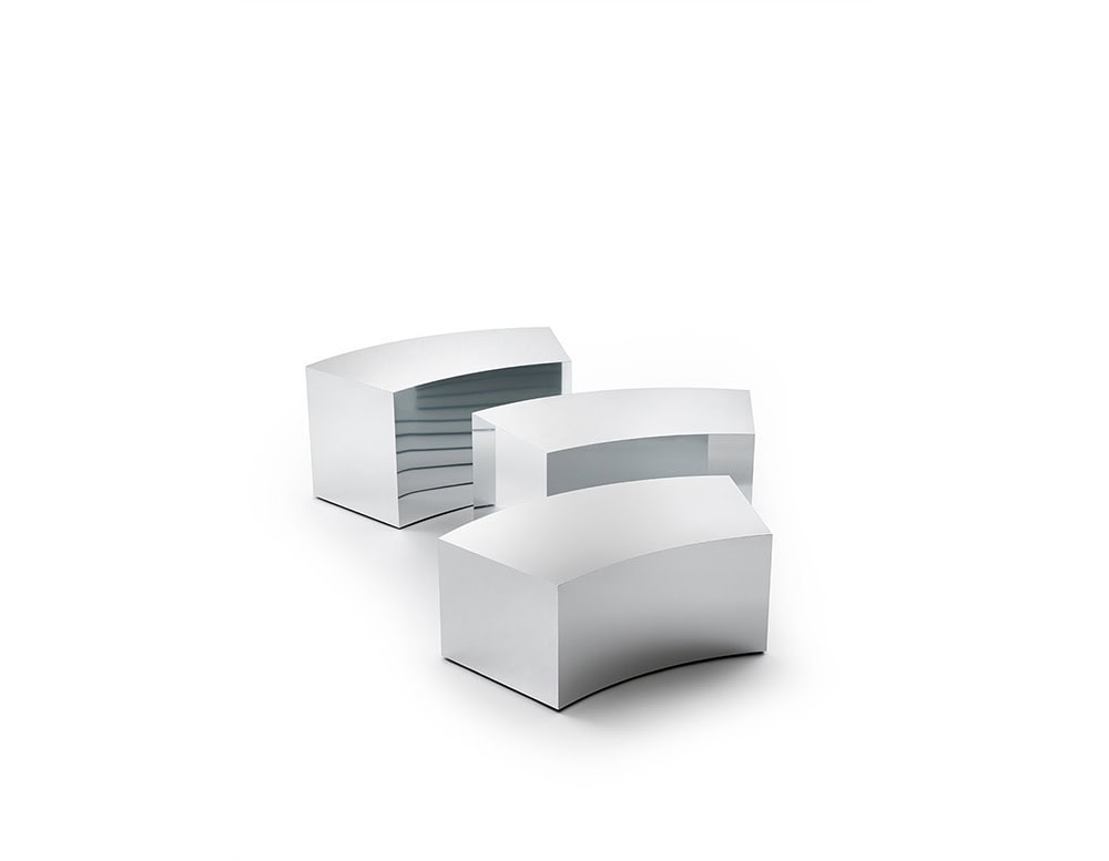 The GR Arch Coffee Table features modular curved blocks with sleek, reflective surfaces. The silvery metallic finish subtly captures surrounding tones, creating a cool, polished aesthetic.
