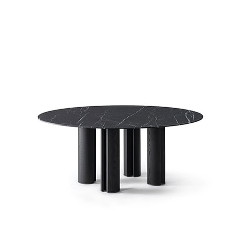 The GR Simpodio W Table features a round top in black marble with subtle veining, resting on cylindrical dark wood legs. The piece is showcased against a minimal white background, emphasizing its bold geometry.