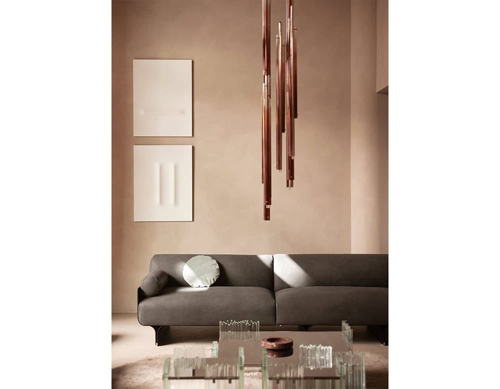 The GR Tratto Suspension Light forms a sculptural cascade of slender elements. Its warm metallic finish creates an elegant vertical accent, softly reflecting light against the neutral interior.