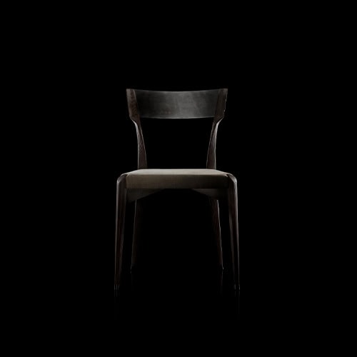 The Hen Chair VA showcases a sleek wood structure with a soft upholstered seat and a gently arched backrest. Its clean lines and subtle curvature bring comfort and sophistication to any dining or living setting.