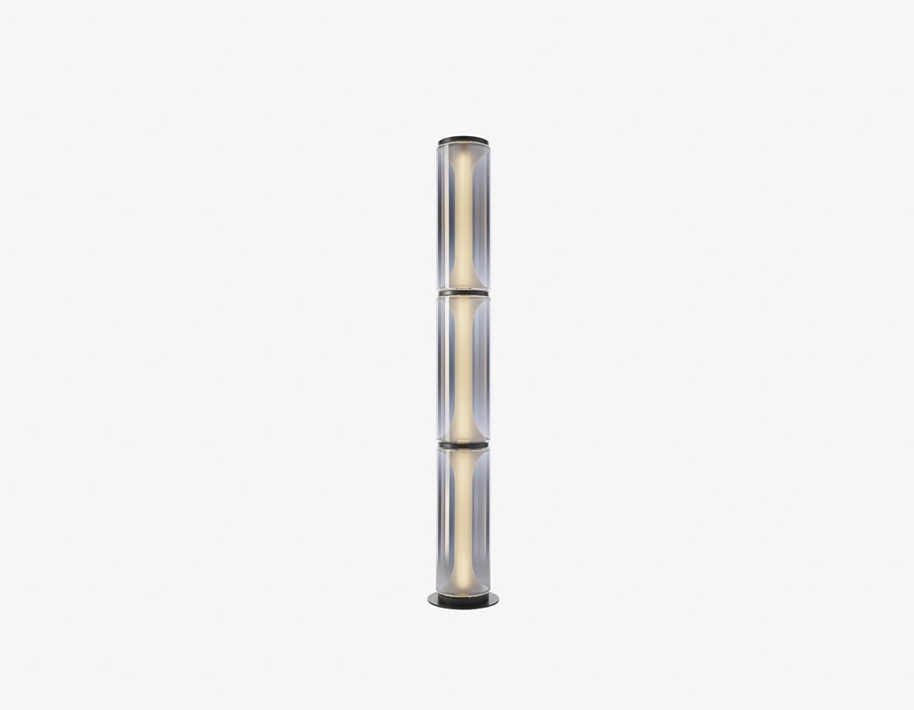 A striking floor lamp featuring stacked smoked glass cylinders with a soft internal glow, adding sculptural elegance and ambient light to any modern space.