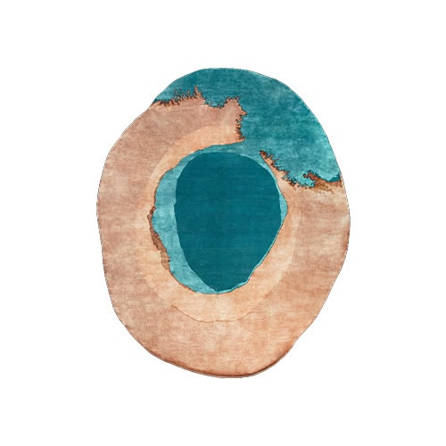 The Sah Bonsai Rug evokes natural landscapes with layered tones of teal and sand. Its organic oval form and textured design create a calming centerpiece that adds warmth and artistry to modern interiors.