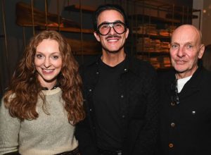 Smiling guests pause for a photo as they enjoy the warm, lively atmosphere of the showroom event, surrounded by elegant design details and great company.