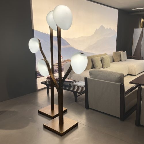 Sculptural floor light with branching bronze stems and soft white glass globes. Organic and tree like, it adds warm ambient glow to the space, contrasting dark metal tones with milky diffused light in a modern interior setting.