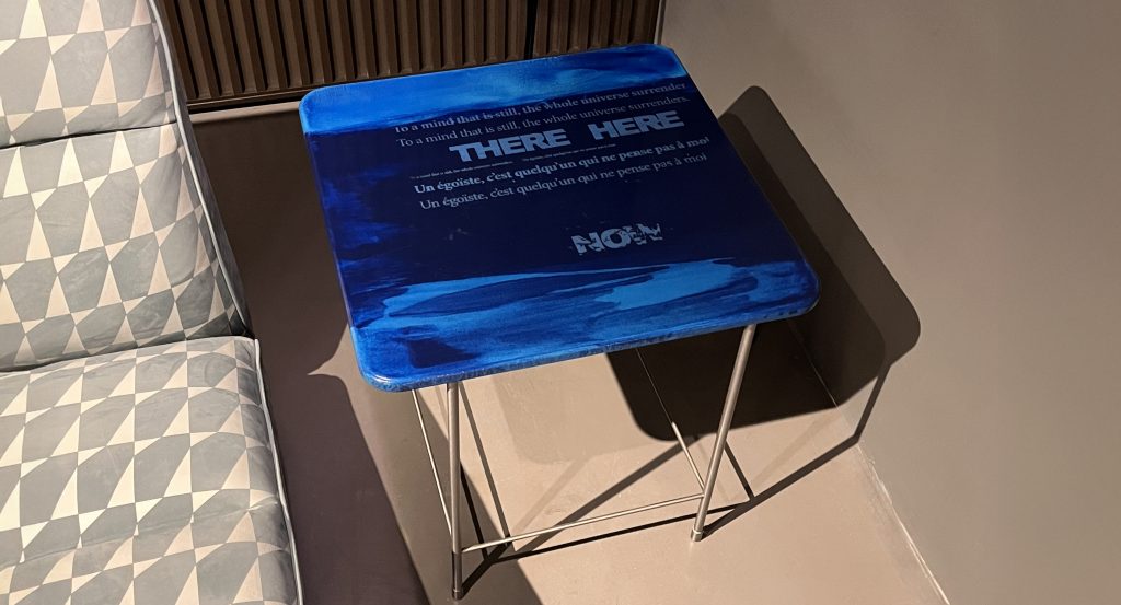 A compact accent table with a vivid blue top that adds depth and character to any setting. The expressive surface pairs with a light metal base, creating a balanced mix of artistic presence and everyday functionality.