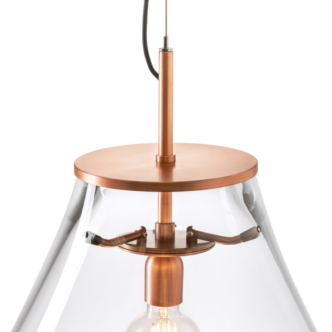 A refined pendant light featuring a clear glass shade and warm copper hardware. The visible filament bulb and precise metal detailing create a balanced blend of industrial character and elegant, contemporary design.