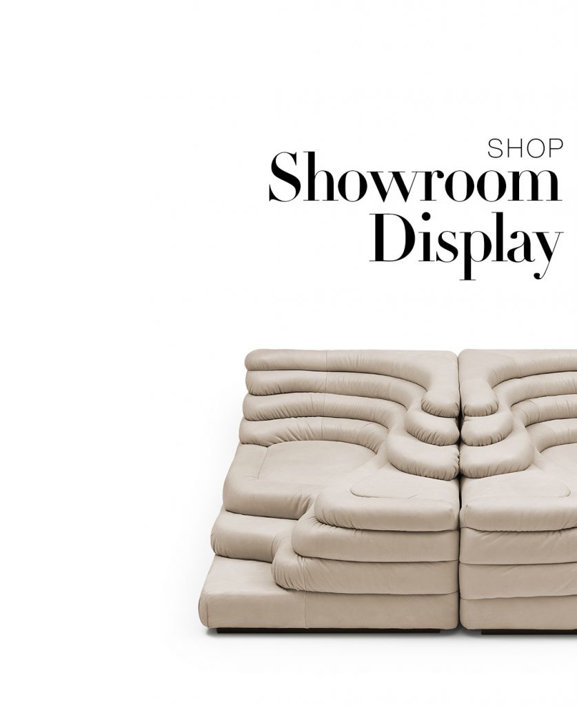 A sculptural modular sofa defines this showroom display with its soft, layered curves and generous proportions. Upholstered in a warm neutral tone, it brings comfort and bold design together in a refined, contemporary setting.