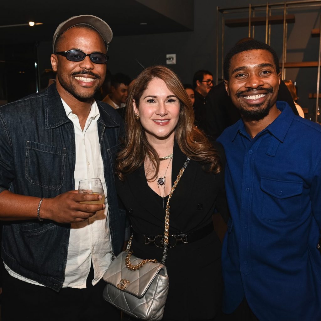 Guests pose together during the evening celebration, enjoying a stylish and welcoming atmosphere inside the contemporary showroom setting.