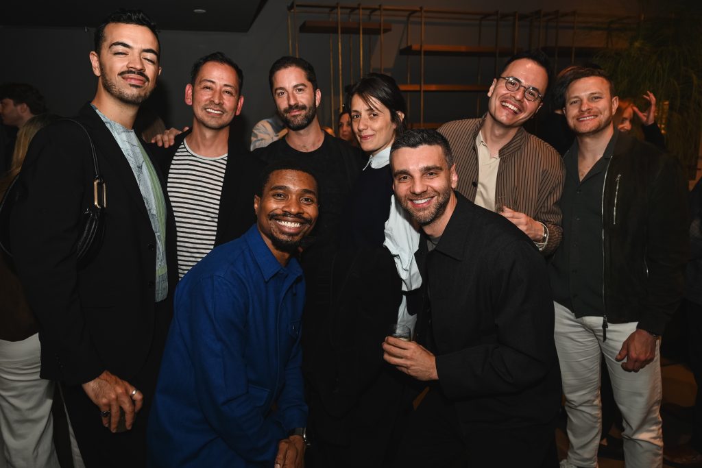 Guests gather for a lively group portrait during the evening celebration, enjoying a warm atmosphere of creativity, connection, and contemporary design.