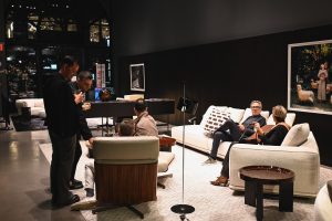 Guests relax and connect throughout the elegant showroom, enjoying conversation and contemporary design in a warm and sophisticated setting.