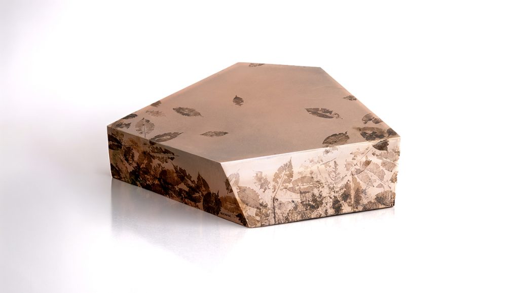 This low table features a faceted silhouette cast in translucent resin with preserved leaves embedded throughout. Organic textures and botanical details add depth and character, creating a sculptural piece that bridges nature and contemporary design.