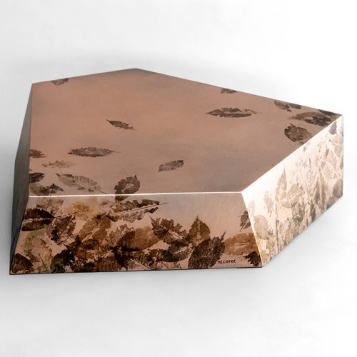 This low table features a faceted geometric form in translucent resin with preserved leaves and botanical fragments. Its sculptural profile and layered organic textures create depth, balancing natural beauty with contemporary design.