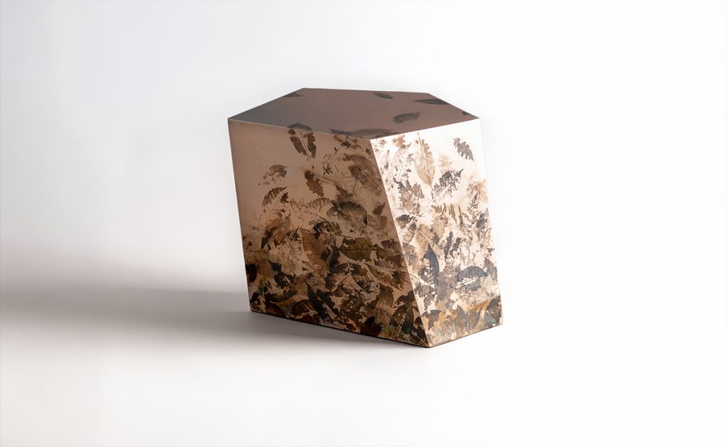 This side table features a faceted geometric form cast in translucent resin with preserved leaves and botanical fragments. Layered organic textures create depth and visual interest, balancing natural inspiration with contemporary craftsmanship.