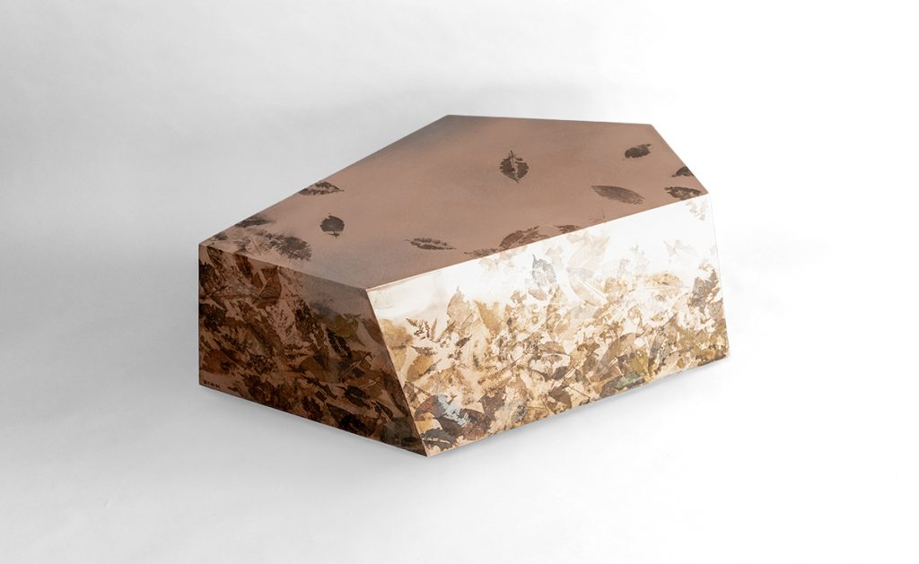 Leafprint Coffee Table features a sculptural geometric form crafted from translucent resin infused with preserved botanical elements. Embedded leaf patterns create a layered organic texture, blending natural inspiration with contemporary design.